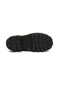 Suela de bota de goma negra con surcos profundos y patrones de agarre texturizados, diseñados para ofrecer tracción y durabilidad.