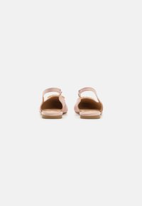 Sandalias de cuero rosa con tacón bajo, espalda abierta y detalle decorativo de cadena en la correa. Textura suave y diseño minimalista.