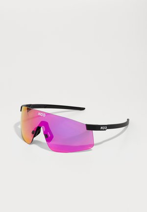 Lunettes de soleil avec une monture noire et de grandes lentilles roses dégradées. Présente un design géométrique et un logo sur le côté. Matériau léger.