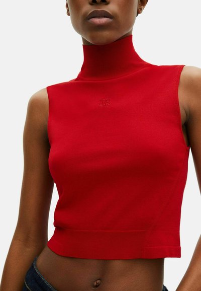 Top sin mangas de color rojo con cuello alto, confeccionado con una tela suave y elástica. Presenta un diseño ajustado y un sutil detalle de logo cerca del escote.