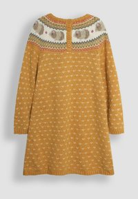 Neulemekko sinapinkeltaisena, jossa on Fair Isle -kuvio kaula-aukossa, nappikiinnitys ja pieniä valkoisia sydämiä vartalolla.
