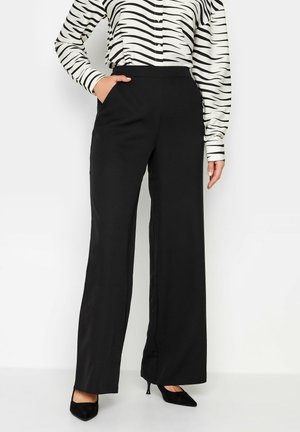 Pantalones de pierna ancha negros, hechos de una tela suave, con bolsillos laterales y una cintura ajustada, combinados con una blusa de estampado.