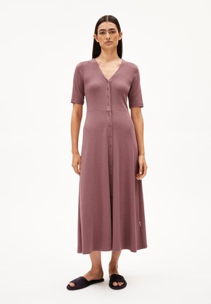 Midi dress in dusty rose with short sleeves, V-neck, ribbed texture, and front button closure. Worn with black slides.