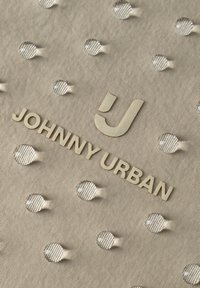 Tissu beige avec un motif de pois en relief, comprenant un logo en relief et le texte "JOHNNY URBAN" dans une couleur beige assortie.