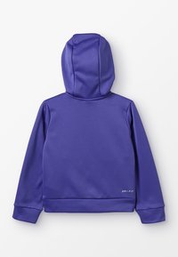 Fioletowa bluza z kapturem wykonana z gładkiego syntetycznego materiału. Posiada logo Dri-FIT na dolnym brzegu. Prosty, strzelisty design z kapturem.