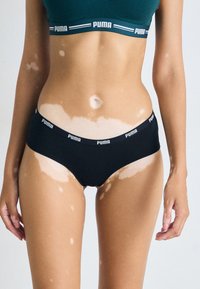 Sorte bomulls-bikini-truser med PUMA-logo. Har en glatt tekstur og en lav midje-design som fremhever en minimalistisk stil.