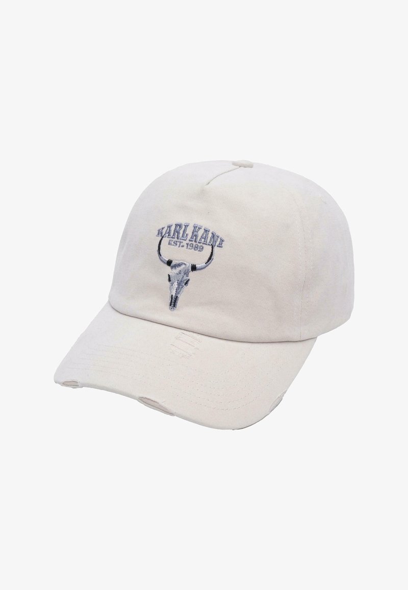 Beige színű pamut sapka ívelt karimával, kék hímzett szarvasbika koponya mintával és "KARL KANI EST. 1989" felirattal a tetején. Megkopott díszítések láthatók.