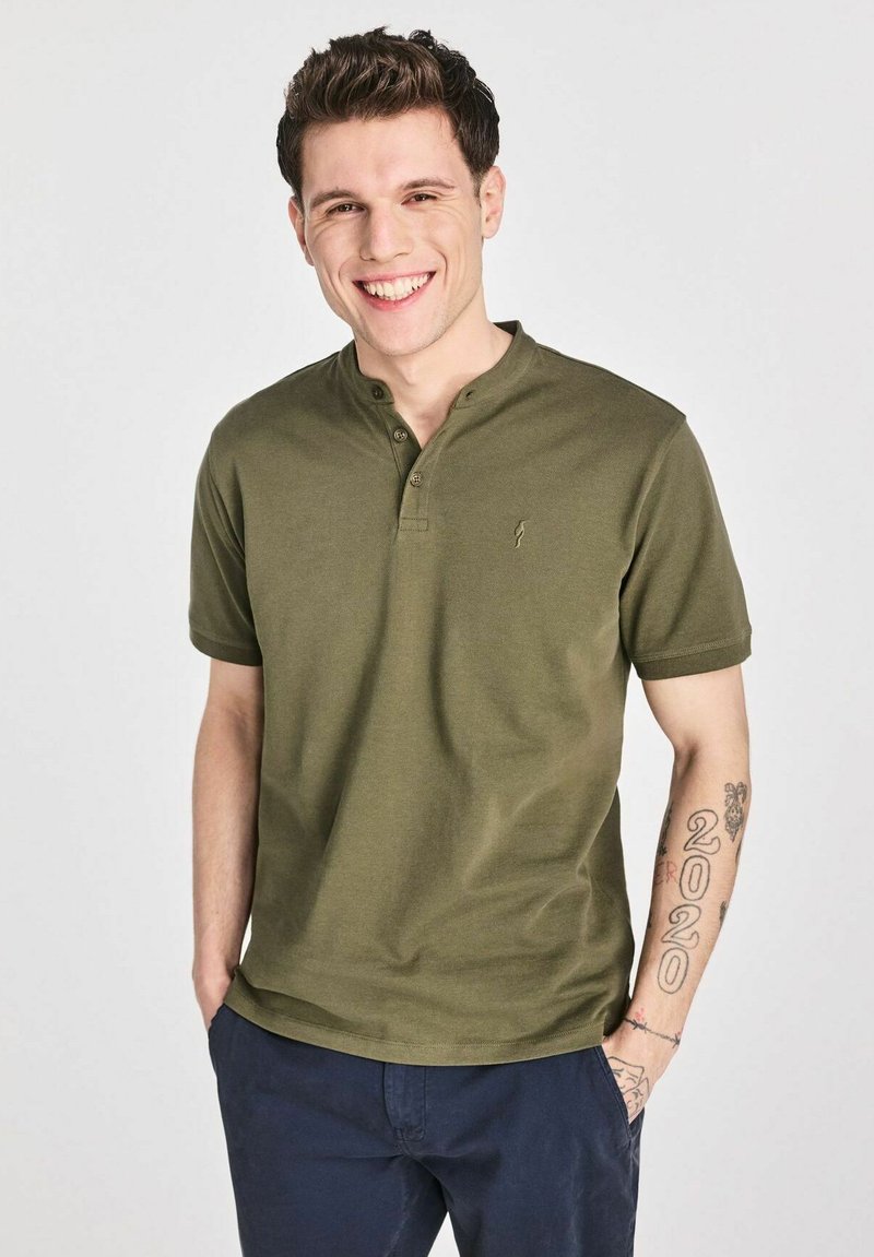 Oliwkowa koszulka polo z krótkim rękawem, z trzema guzikami i subtelnym logo. Gładki bawełniany materiał o luźnym kroju.