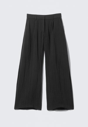Black wide-leg trousers made from a textured fabric. Features a high waist, pleats at the front, and open cuffs.