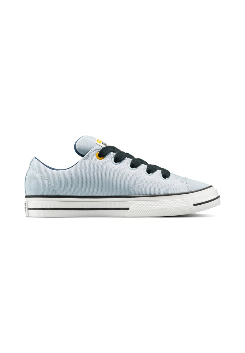 Sneaker in tela azzurro chiaro con lacci neri, suola in gomma bianca e strisce nere e bianche. Presenta un accento giallo sulla linguetta.