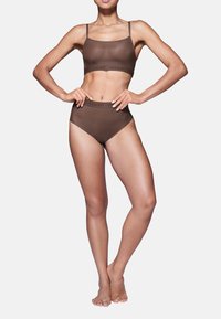 Bruine naadloze bralette met dunne bandjes en bijpassende high-waisted slipjes, beide met subtiele tonale branding langs de taille.