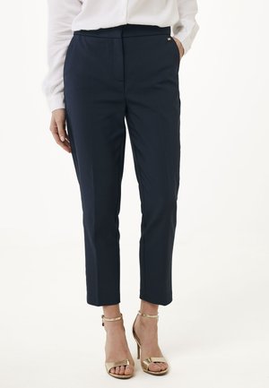 Pantaloni tailored blu navy con vestibilità slim, caratterizzati da un davanti piatto e tasche laterali, completati da dettagli in metallo dorato e lunghezza cropped.