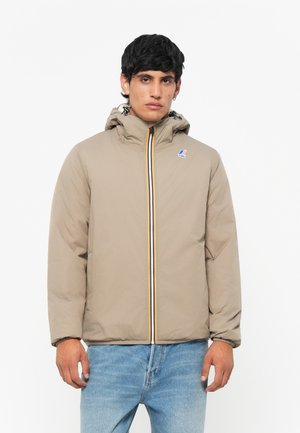 Beige pufferjack met een capuchon, een ritssluiting aan de voorkant en kleurrijke gestreepte accenten. Beschikt over een logo-patch op de borst en elastische manchetten.