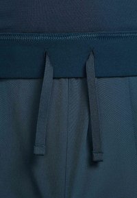 Mörkblå sportshorts med elastisk midjeresår, justerbara dragsnören och slät, texturerad tyg.