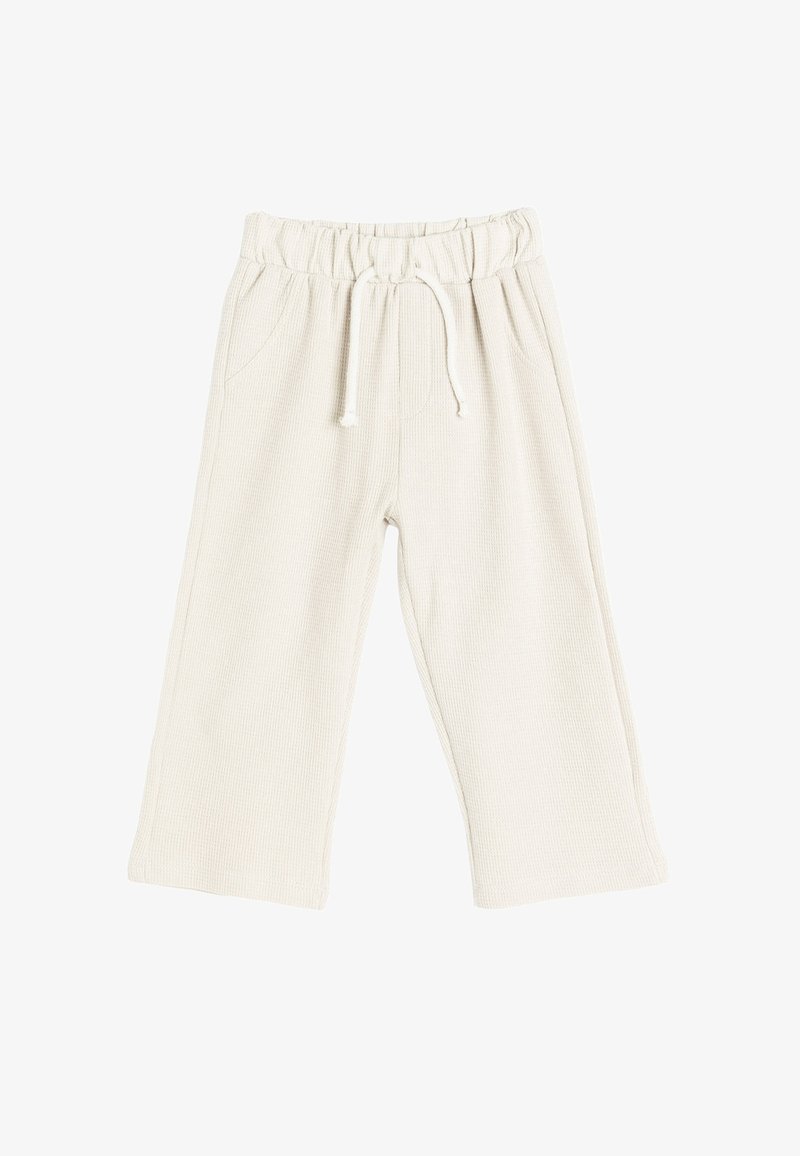 Cremfarbene, gerippte Stoff-Hosen mit weitem Bein, elastischem Bund und Kordelzug. Mit zwei seitlichen Taschen.