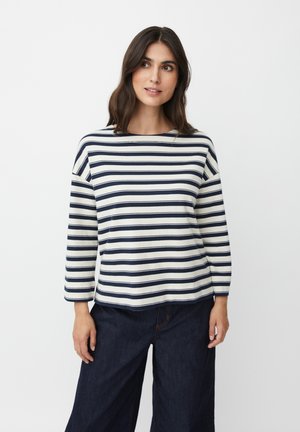 Maglietta a maniche lunghe a righe blu navy e bianche con scollatura rotonda, vestibilità comoda e morbido cotone, abbinata a pantaloni ampi in denim scuro.