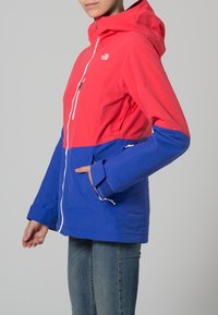 Giacca impermeabile a blocchi di colore con la parte superiore rosa e la parte inferiore blu, chiusura con zip, cappuccio regolabile e tasche laterali.