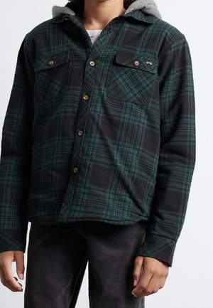 Kariertes Flanellhemd in Schwarz und Dunkelgrün mit Knopfleiste, zwei Brusttaschen und angenähter grauer Kapuze. Weiche Textur, lässiges Design.