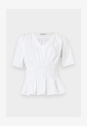 Blouse blanche à manches courtes avec col en V, taille élastique froncée, épaules légèrement bouffantes et ourlet péplum, posée à plat sur un fond clair.