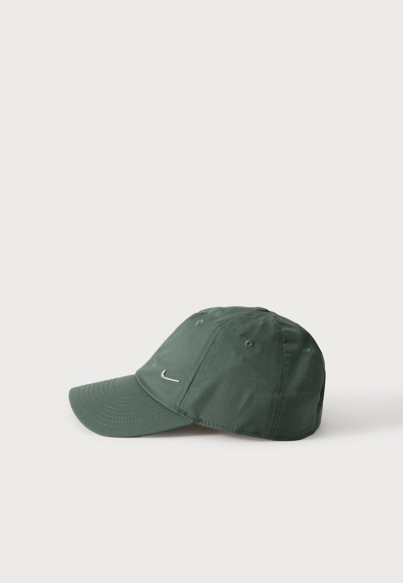 Dunkelgrüne Baseballkappe mit kleinem weißem Nike-Logo auf der Vorderseite, vor einem schlichten hellen Hintergrund dargestellt.