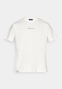 T-shirt de algodão creme com mangas curtas, gola redonda e um pequeno texto bordado azul no peito. Inclui uma etiqueta na barra.