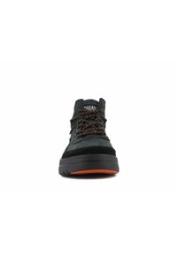 Baskets montantes noires décontractées avec des lacets et une semelle accentués en orange, marquées « Palladium » sur la languette, vue de face.