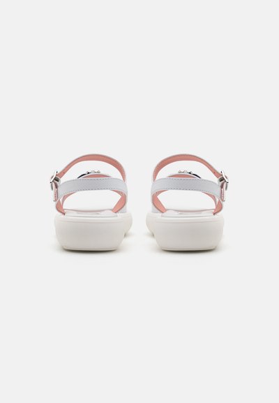Sandalias blancas con dos correas ajustables grises, acentos rosas y una suela blanca gruesa y redondeada. Detalle de hebilla en la correa.