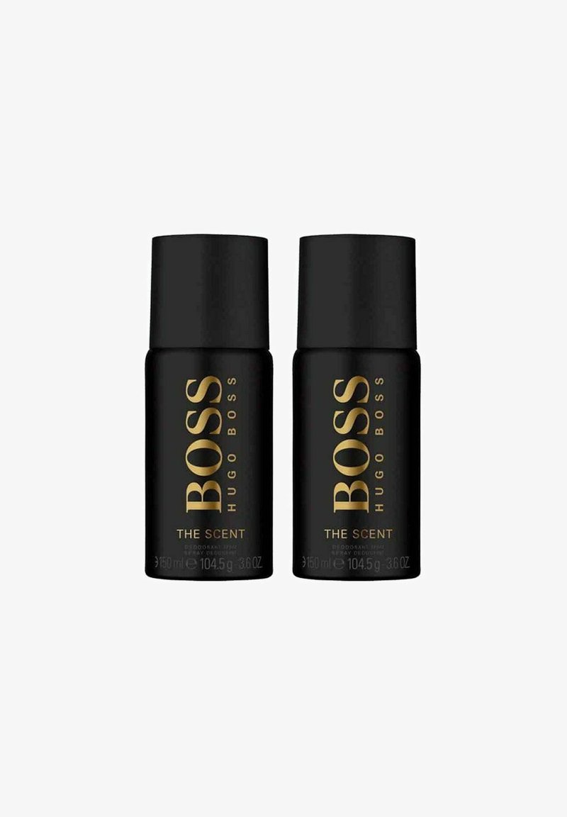 Mustasilmukkeet deodorantista mustilla sylinterimäisillä muodoilla, joissa on kultainen teksti "BOSS HUGO BOSS THE SCENT". Jokaisen pullon tilavuus on 150 ml.