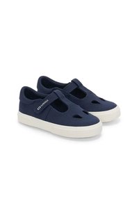 Scarpe in tela blu navy con design a ritaglio, cinturino in Velcro e suola in gomma bianca testurizzata. Costruzione leggera e traspirante.