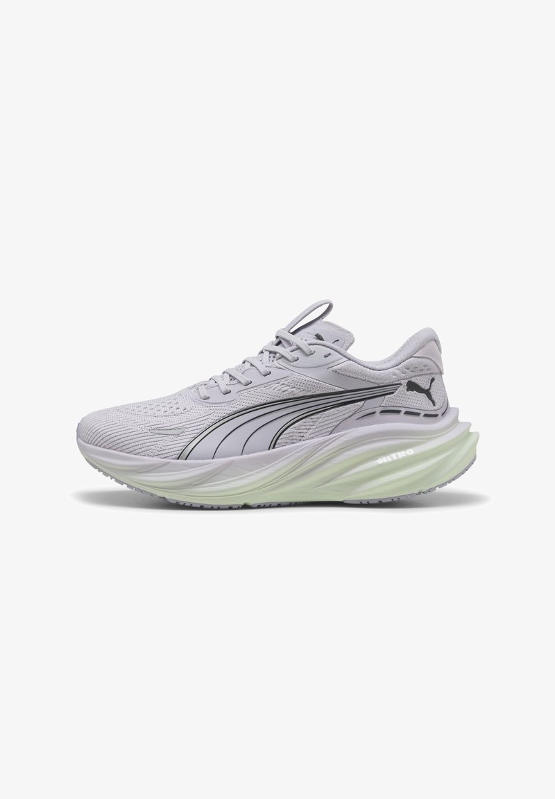 Zapatilla deportiva de color gris claro con parte superior de malla texturizada, detalles en negro y una suela gruesa y acolchada de color verde. Presenta un diseño de cordones y talón moldeado.