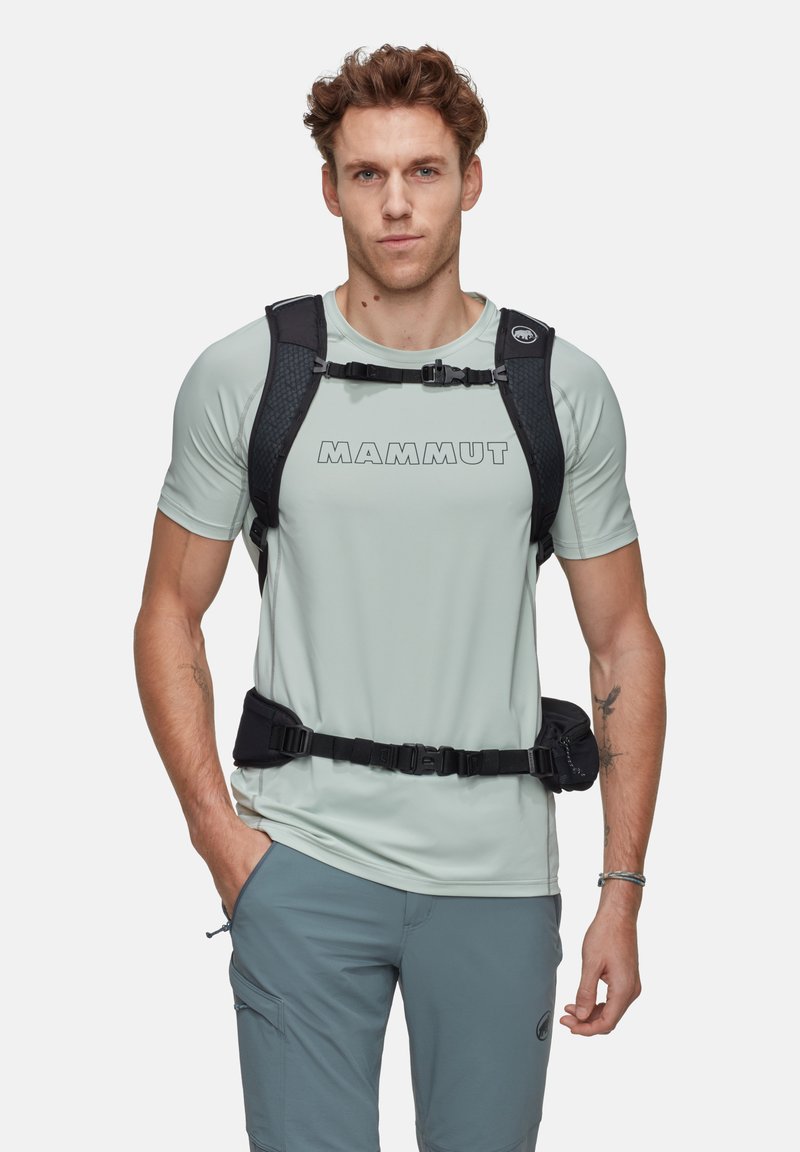 Ljusgrå teknisk t-shirt med "MAMMUT"-logotyp, kombinerad med cargoshorts. Inkluderar ett svart selen-system och justerbart rem för stöd.