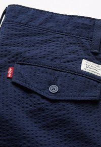 Kalhoty z texturované tkaniny v námořnické modré barvě s zapínáním na knoflík, kapsou s knoflíkem a štítkem s logem "Levi's".
