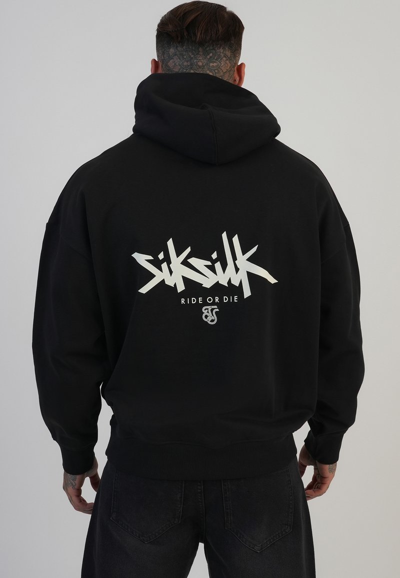 Črna kapuca z velikim belim grafičnim besedilom na hrbtni strani, ki vsebuje ime blagovne znamke "Siksilk" in frazo "Ride or Die."