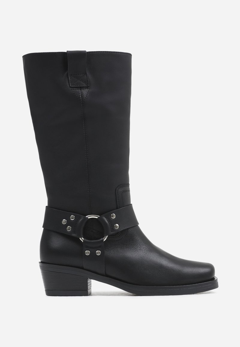 Czarne skórzane buty za kolano z zaokrąglonym noskiem, podwyższonym obcasem oraz szerokim paskiem z metalowym pierścieniem i ozdobnymi ćwiekami.