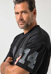 Czarna sportowa koszulka z siateczkową teksturą, krótkimi rękawami oraz numerem "14" w kolorze szarym na lewym rękawie.