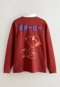 Langärmliges rotes Hemd mit weißem Kragen, das eine orange Umrandung von Snoopy und Woodstock zeigt, sowie blauen japanischen Text darüber auf dem Rücken.