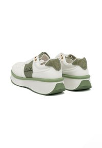 Sneaker bianco con accenti verdi, parte superiore testurizzata, suola spessa e branding minimale. Presenta occhielli decorativi e un motivo sul tallone.