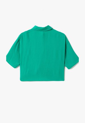 Lyhythihainen, kauluksellinen paita yksivärisessä kirkkaassa vihreässä, jossa on sileä, kevyt kangas ja laatikkomainen malli suoran helman kanssa.