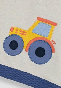 Gelbes und blaues gesticktes Traktor-Design auf leicht grauem Stoff, mit marineblauen gerippten Bündchen und Details wie Rädern und Abgasakzenten.