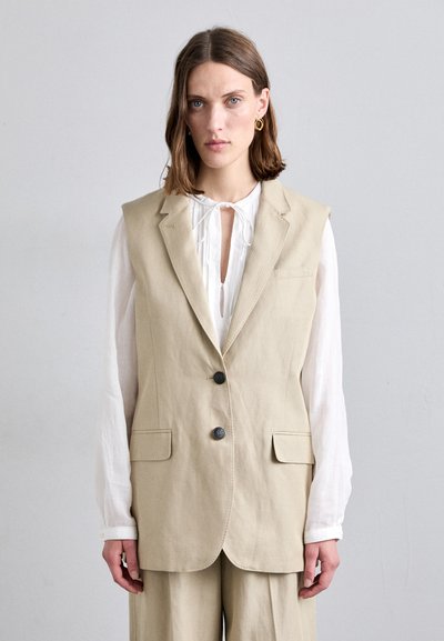 Beige linnen vest met een op maat gemaakte snit, voorzien van een notch kraag, twee voorzakken en twee donkere knopen.