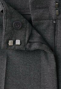 Ciemnoszare spodnie z tkaniny, wyposażone w zamek błyskawiczny, guzik oraz metalowe dodatki. Tekstura jest gładka z delikatnym wzorem.