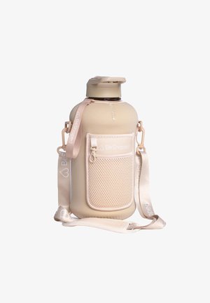 Botella grande de agua beige con una funda de silicona texturizada, correa de transporte y un bolsillo de malla. Presenta una tapa de rosca segura y un detalle de logo.