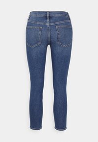 Smal jeans i denim, med en mörkblå färg, avsmalnande ben, två bakfickor och en standard midja med bälteshällor.
