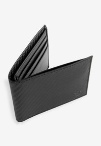 Portefeuille noir avec une texture semblable à du carbone, comportant plusieurs emplacements pour cartes et une poche à pièces, accentué par un logo embossé sur un côté.