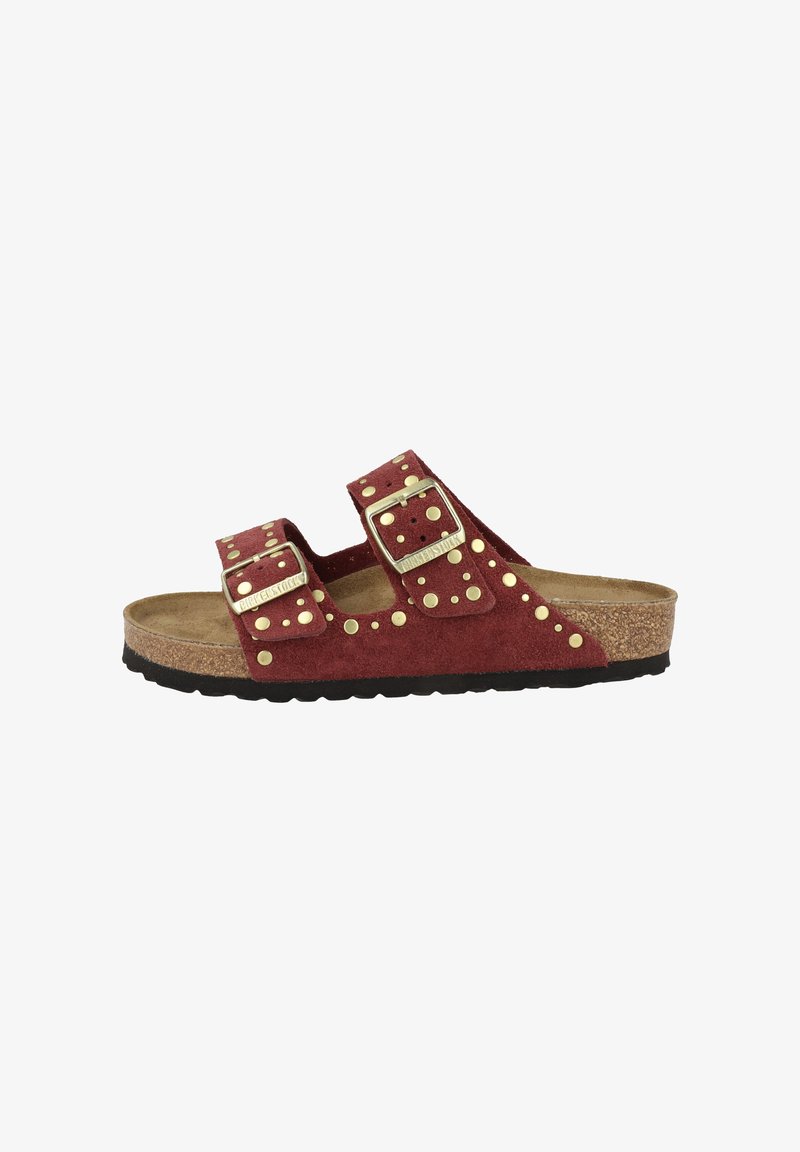 Rode suède slide-sandaal met twee verstelbare banden, gouden studs en een getextureerde kurken voetbed. Zwarte rubberen buitenzool.