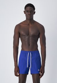 Costume da bagno blu con cintura elastica e lacci bianchi. Presenta un piccolo logo sulla parte sinistra. Tessuto strutturato.