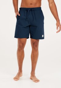 Shorts de bain bleu marine en tissu léger avec une taille élastique et un cordon de serrage. Inclut des poches latérales et un écusson logo sur la jambe.