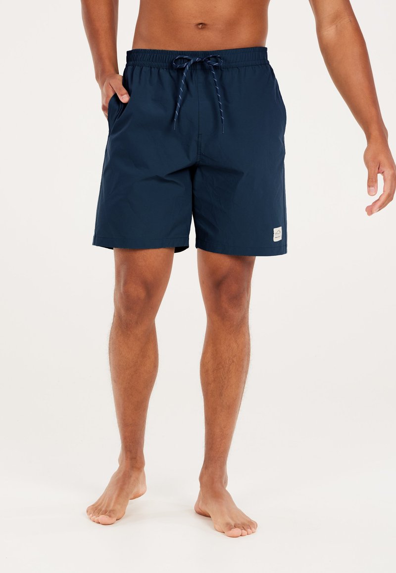 Shorts de bain bleu marine en tissu léger avec une taille élastique et un cordon de serrage. Inclut des poches latérales et un écusson logo sur la jambe.