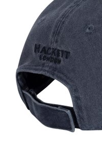 Marinblå bomullsmössa med böjd skärm, broderad "HACKETT LONDON"-logotyp i mörk tråd, justerbar rem baktill, mjuk textur.