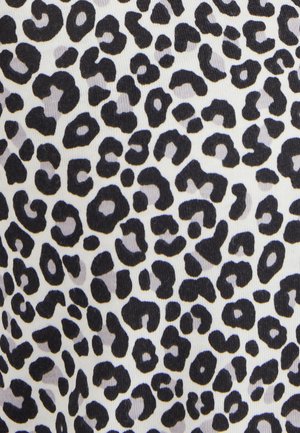 Tessuto a stampa leopardata con macchie nere di varie dimensioni su uno sfondo bianco, con una superficie liscia e strutturata.